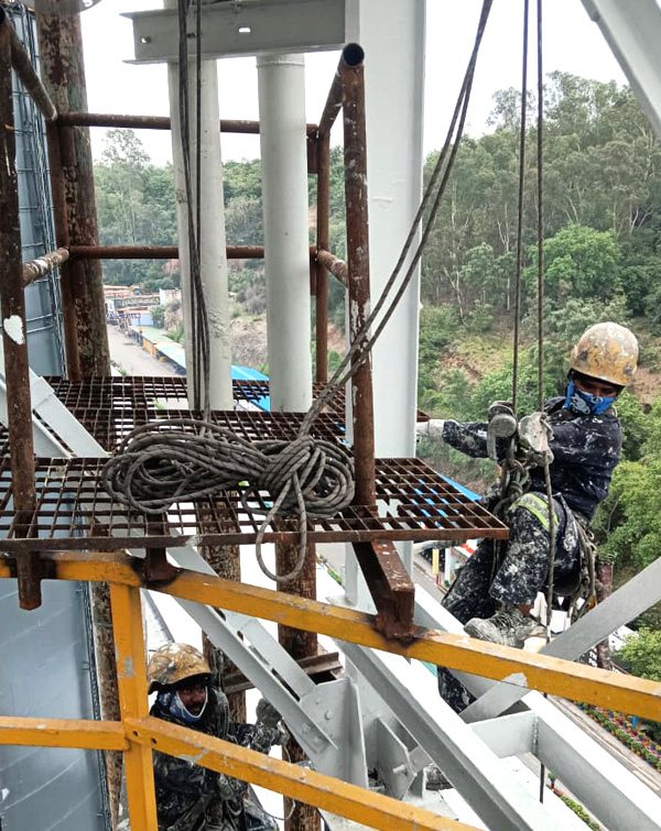 Rope access technician working at height on a plant structure